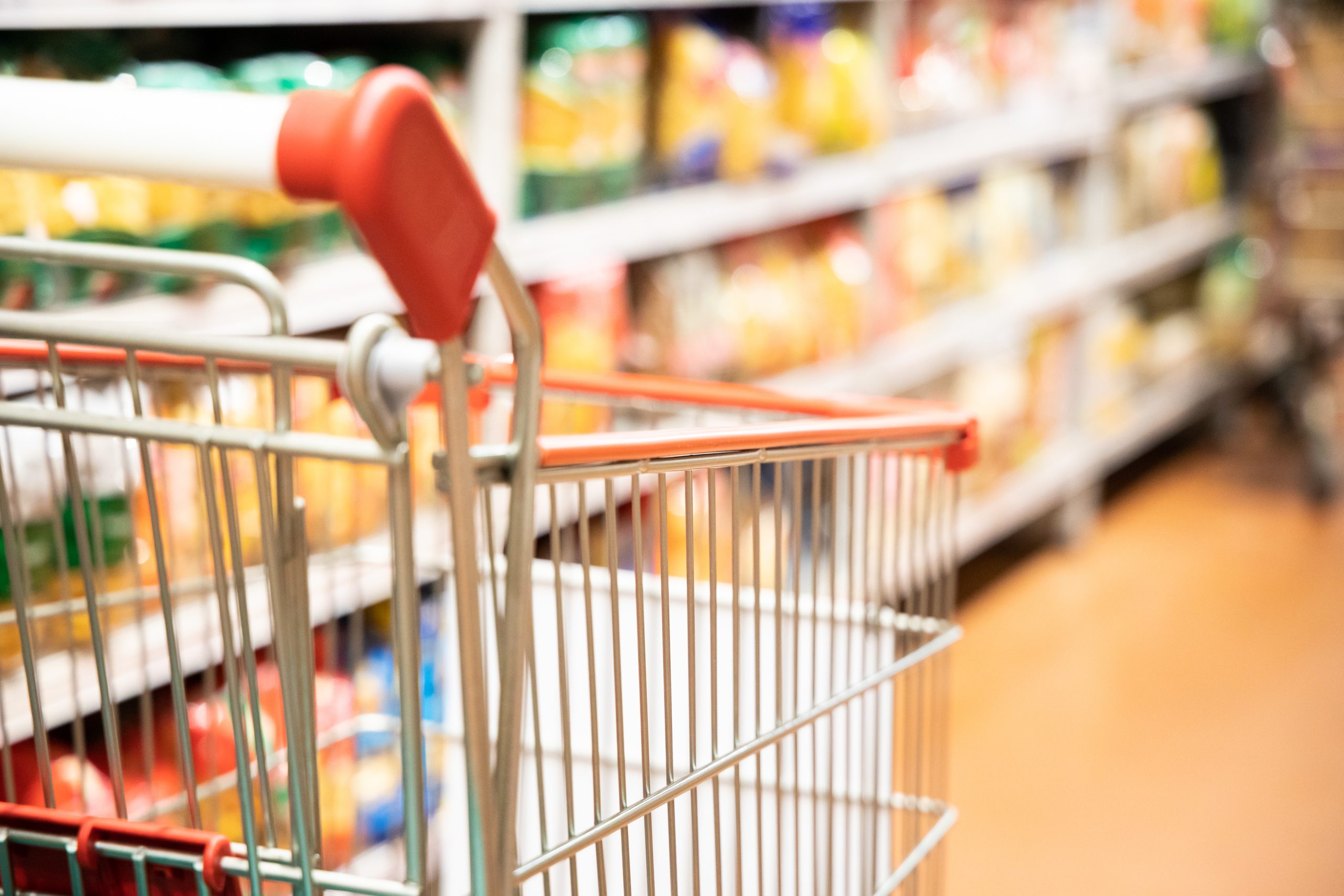 Shopping trolley cart with shallow DOF against supermarket aisle